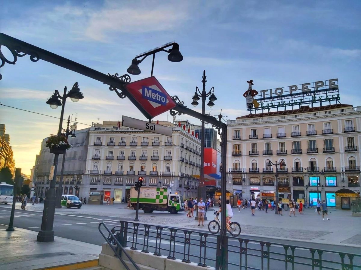 La boca de metro de Sol con el cartel de Tío Pepe al fondo en la Puerta del Sol.
